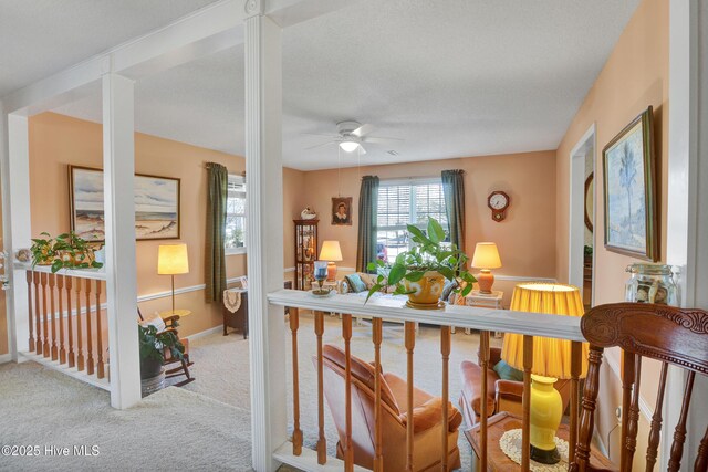 carpeted living room with ceiling fan and a textured ceiling