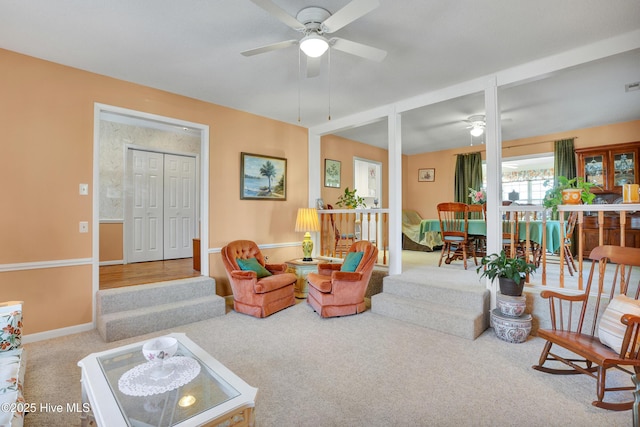 living room with baseboards, ceiling fan, and carpet flooring