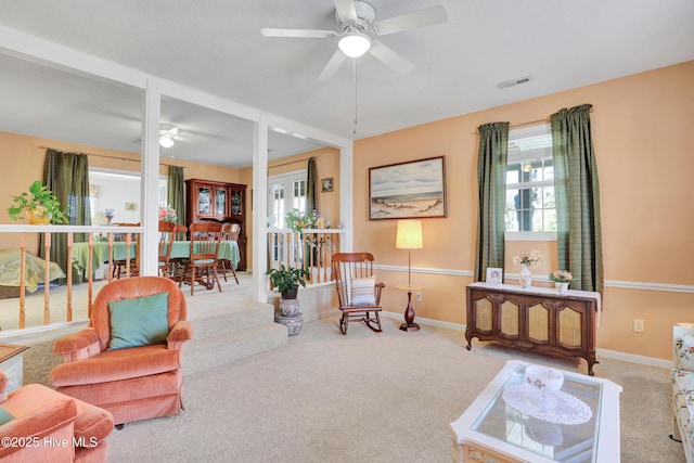 carpeted living area featuring visible vents, baseboards, and ceiling fan