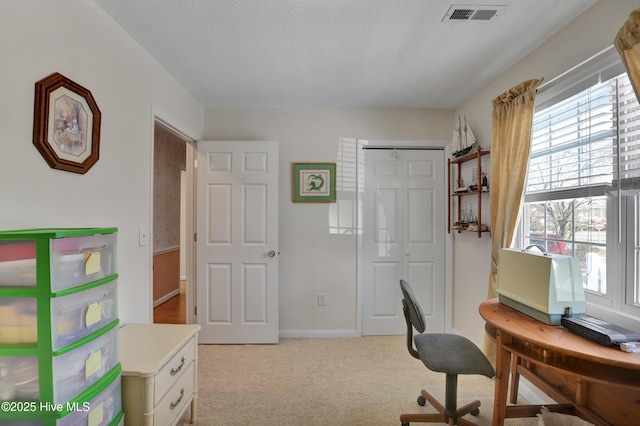 office area featuring visible vents, light colored carpet, a textured ceiling, and baseboards