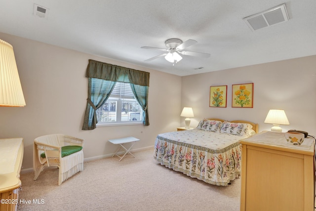 carpeted bedroom with visible vents, a ceiling fan, and baseboards