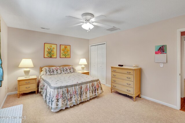 carpeted bedroom featuring ceiling fan, ensuite bath, a closet, and a textured ceiling