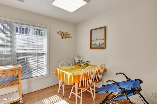 dining area featuring light wood-style flooring and baseboards