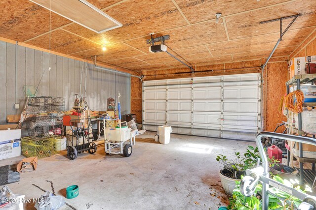 garage with wooden walls and a garage door opener