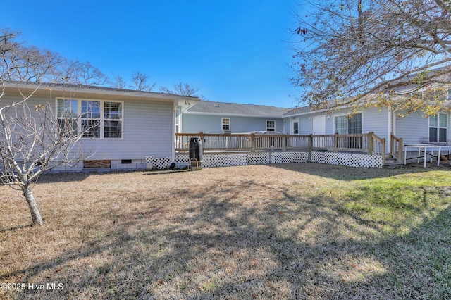 rear view of property with a yard and a wooden deck