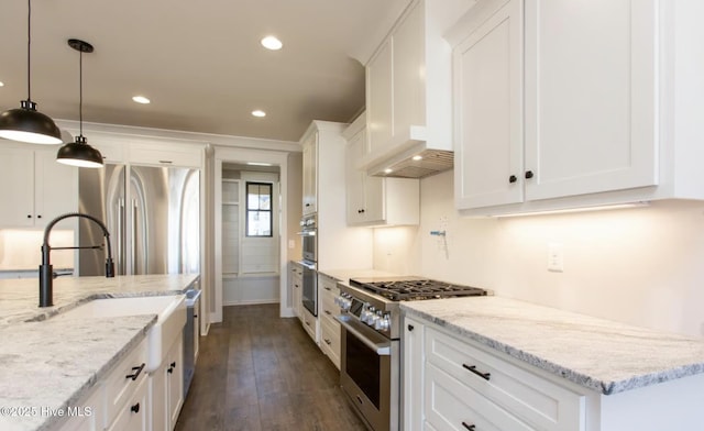 kitchen with pendant lighting, light stone counters, white cabinetry, and stainless steel appliances