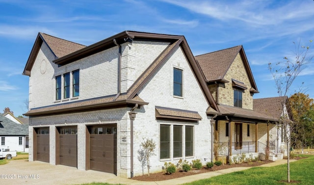 exterior space with covered porch, a yard, and a garage