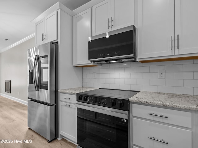 kitchen with light wood-type flooring, ornamental molding, white cabinetry, appliances with stainless steel finishes, and backsplash