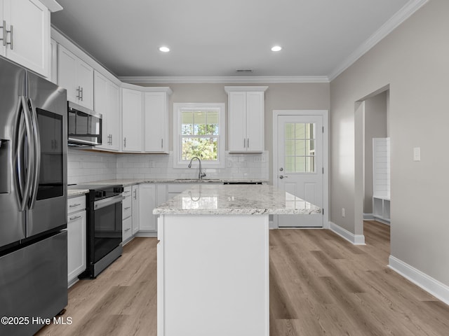 kitchen featuring tasteful backsplash, white cabinetry, ornamental molding, a sink, and stainless steel appliances