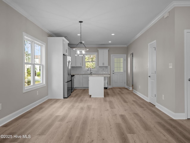 kitchen with ornamental molding, decorative backsplash, freestanding refrigerator, and baseboards