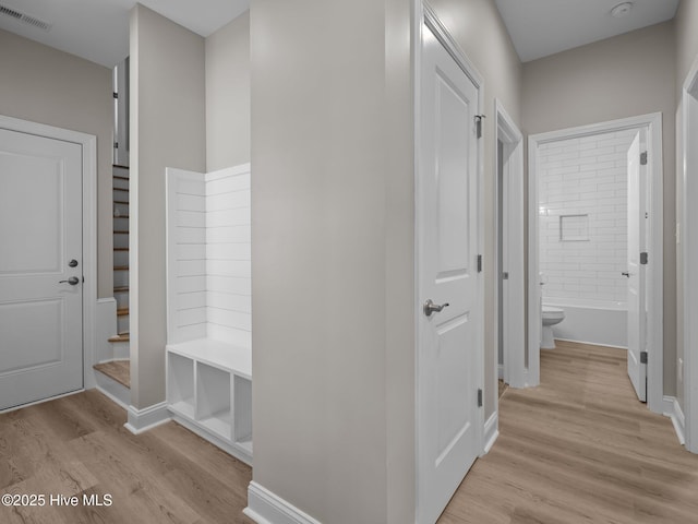 mudroom with light wood finished floors, visible vents, and baseboards
