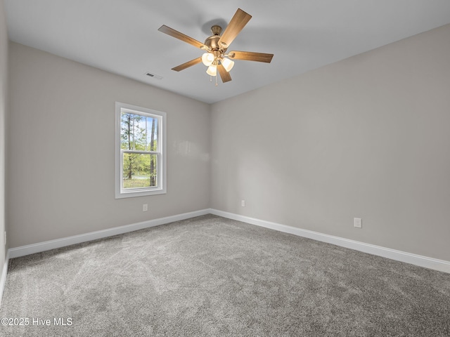 carpeted spare room featuring baseboards, a ceiling fan, and visible vents