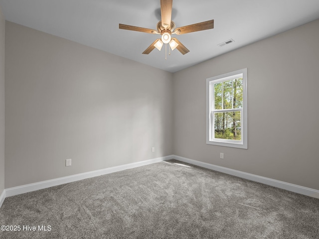carpeted spare room featuring visible vents, baseboards, and ceiling fan