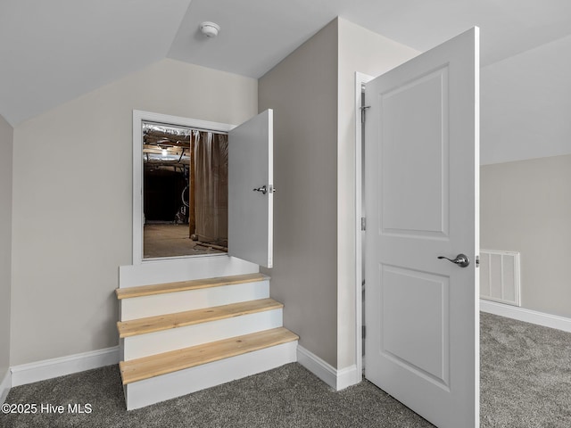 stairs featuring visible vents, baseboards, carpet flooring, and vaulted ceiling