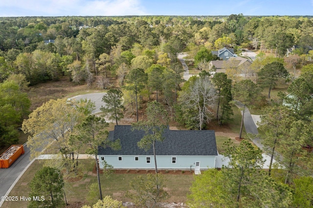 drone / aerial view with a wooded view
