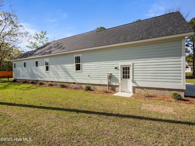 back of property with crawl space, a lawn, and roof with shingles