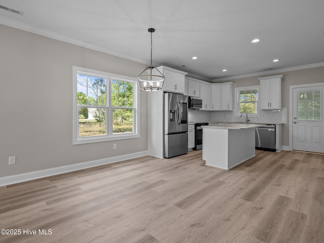 kitchen featuring ornamental molding, a chandelier, backsplash, visible vents, and appliances with stainless steel finishes