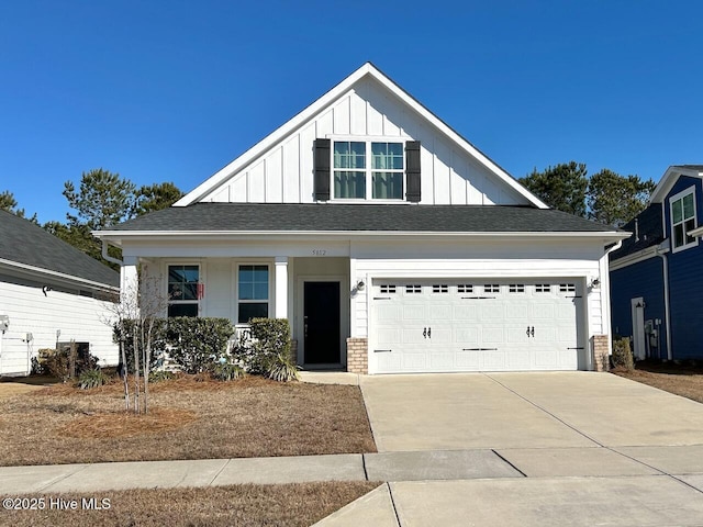 view of front of home with board and batten siding, concrete driveway, brick siding, and a garage