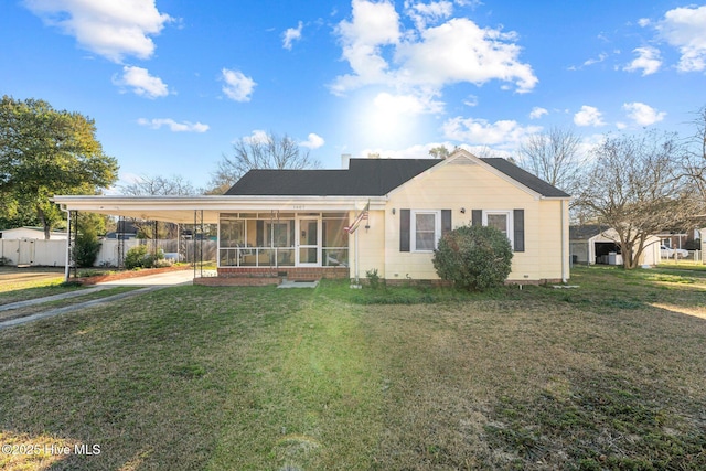 ranch-style home with a carport, a sunroom, and a front yard