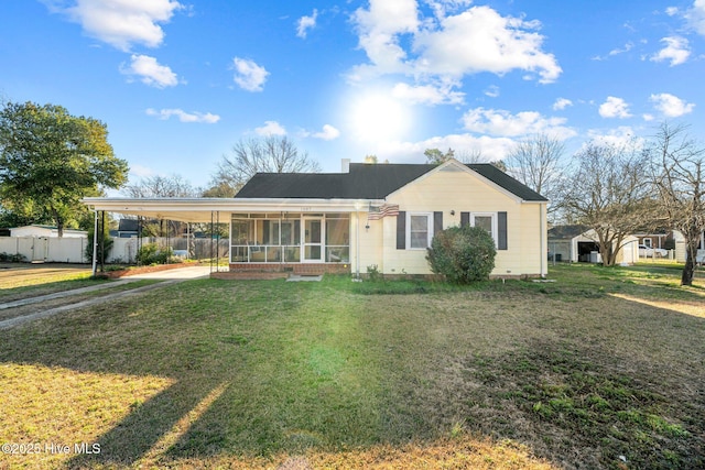 ranch-style home with a carport, a sunroom, and a front yard