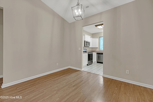 unfurnished dining area with light wood-type flooring and a chandelier