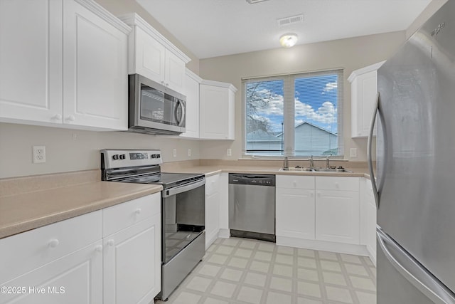 kitchen with sink, white cabinetry, and stainless steel appliances