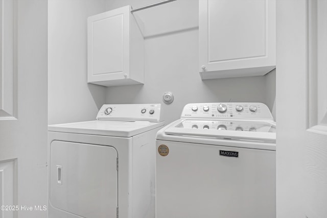 washroom featuring cabinets and washing machine and clothes dryer