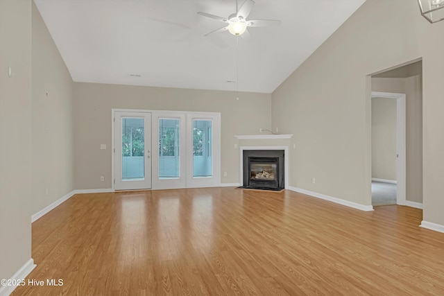 unfurnished living room with ceiling fan, lofted ceiling, and light hardwood / wood-style flooring