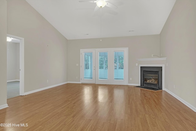 unfurnished living room featuring ceiling fan, lofted ceiling, and light wood-type flooring