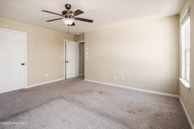 carpeted spare room featuring ceiling fan