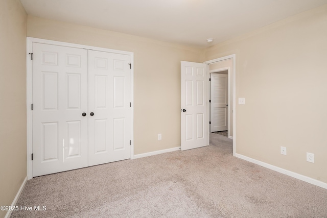 unfurnished bedroom with light carpet and a closet