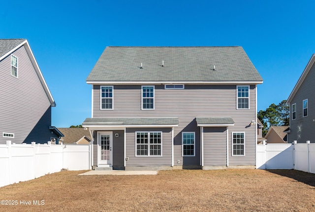 rear view of house featuring a yard and a patio