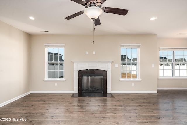 unfurnished living room featuring dark hardwood / wood-style floors, ceiling fan, and a premium fireplace