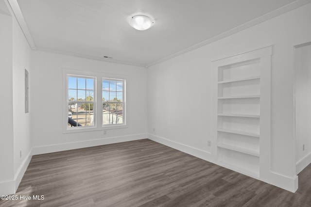 unfurnished room with dark wood-type flooring, built in features, and ornamental molding