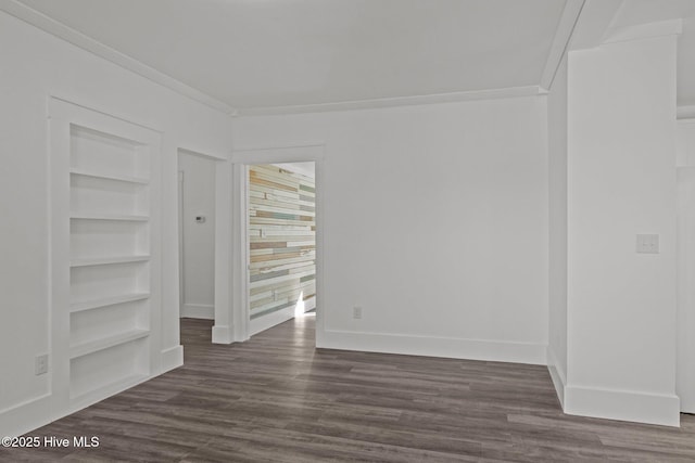 empty room featuring ornamental molding, built in shelves, and dark hardwood / wood-style flooring