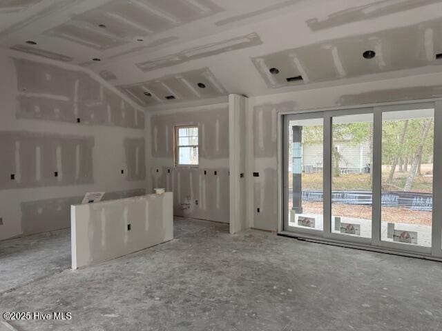 empty room with vaulted ceiling and plenty of natural light