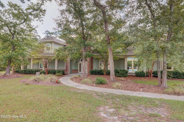 view of property hidden behind natural elements with a front yard