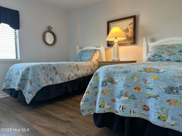 bedroom with dark hardwood / wood-style flooring