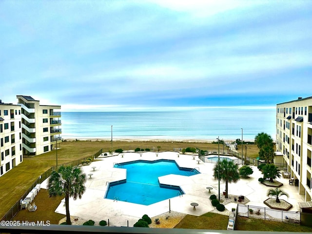 view of pool featuring a water view and a patio