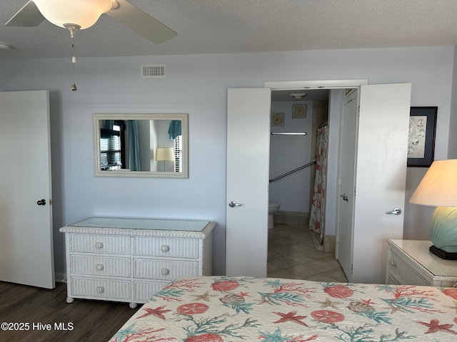 bedroom with ceiling fan, a textured ceiling, and connected bathroom