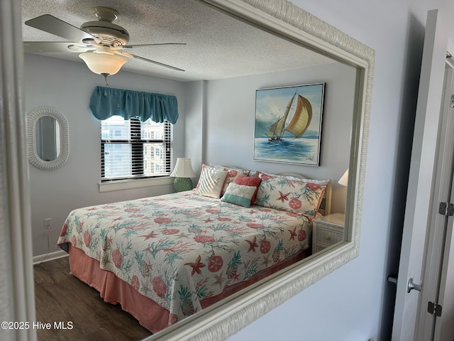 bedroom featuring a textured ceiling, ceiling fan, and dark wood-type flooring