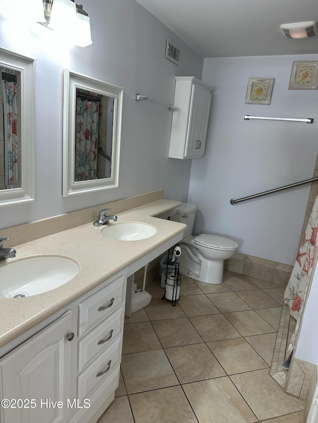 bathroom with tile patterned flooring, vanity, and toilet