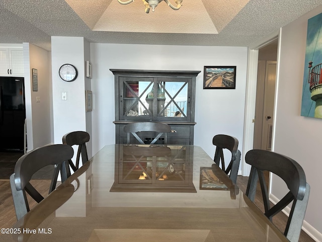 dining area featuring light hardwood / wood-style flooring and a textured ceiling