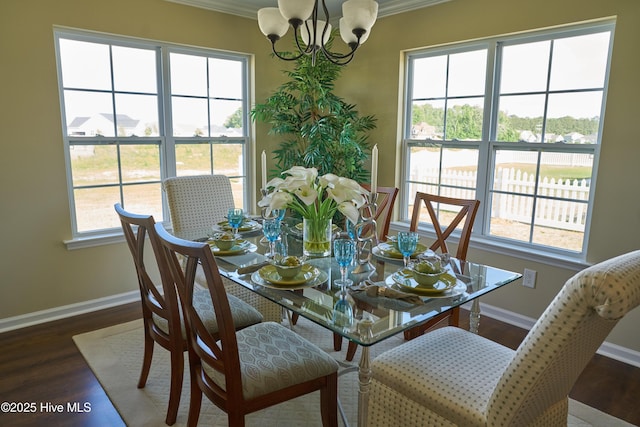 dining area featuring dark wood-type flooring, crown molding, and a chandelier