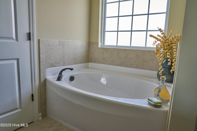 bathroom with a tub to relax in and tile patterned floors