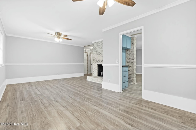 unfurnished living room with light hardwood / wood-style floors, ceiling fan, crown molding, and a fireplace