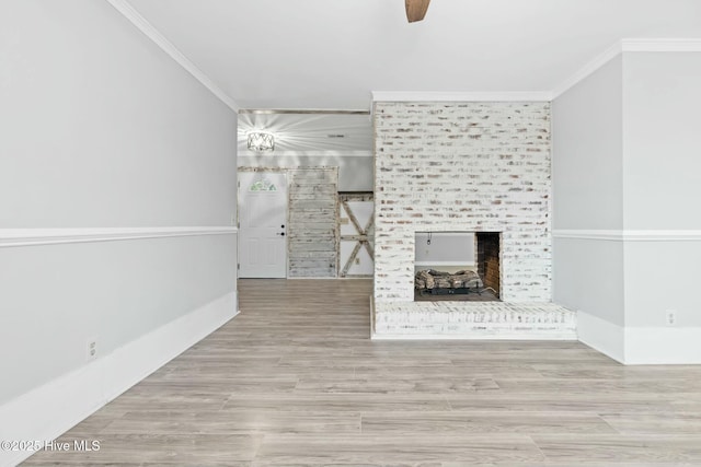 unfurnished living room with light wood-type flooring, ceiling fan, a multi sided fireplace, and crown molding