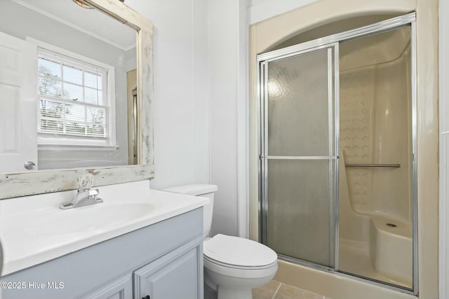 bathroom featuring toilet, an enclosed shower, vanity, and tile patterned floors