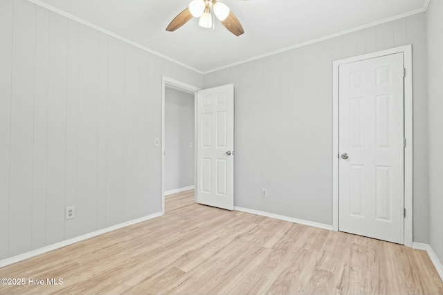 spare room featuring ceiling fan, crown molding, and light wood-type flooring