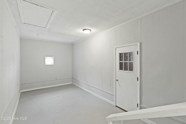 empty room with ornamental molding, concrete floors, and a textured ceiling